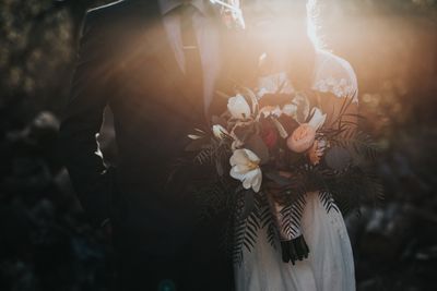 groom standing beside bride holding a bouquet