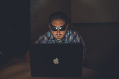 man using laptop with sunglasses on